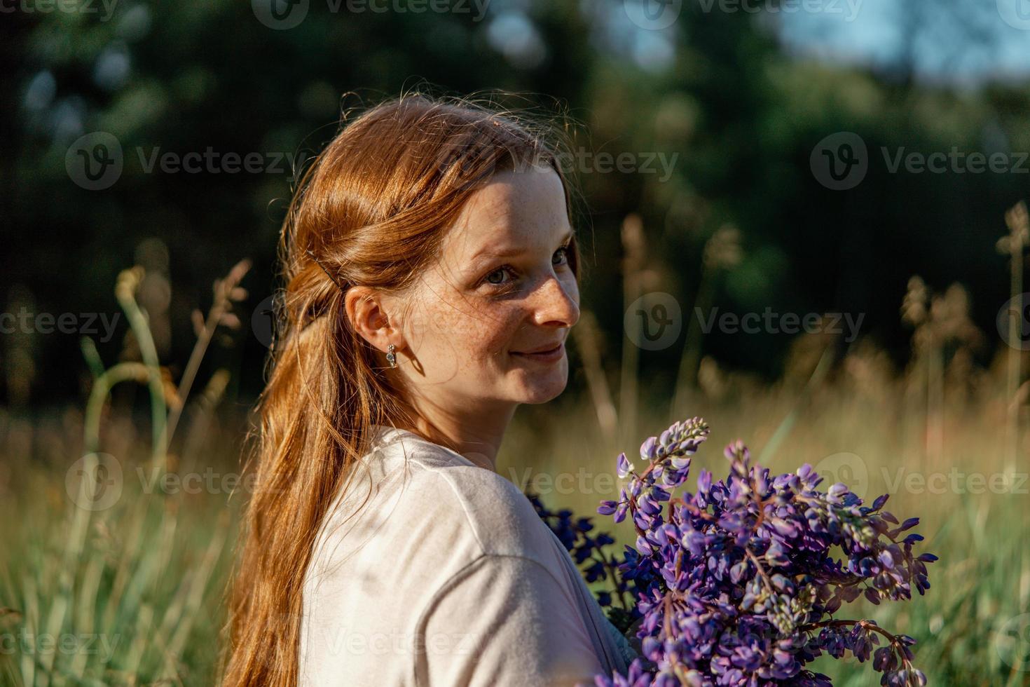 stänga upp porträtt av ung skön rödhårig kvinna med fräknar, bär vit klänning, Framställ i de natur. flicka med röd hår innehav blommor. naturlig skönhet. mångfald, enskild unikhet. foto