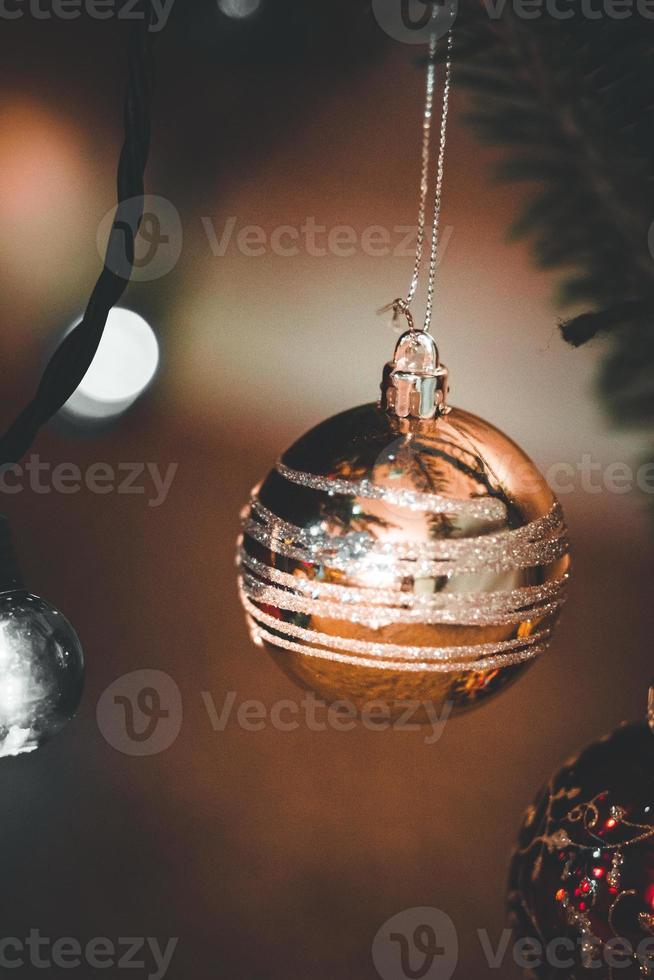 guld jul prydnad hängande på en jul träd foto