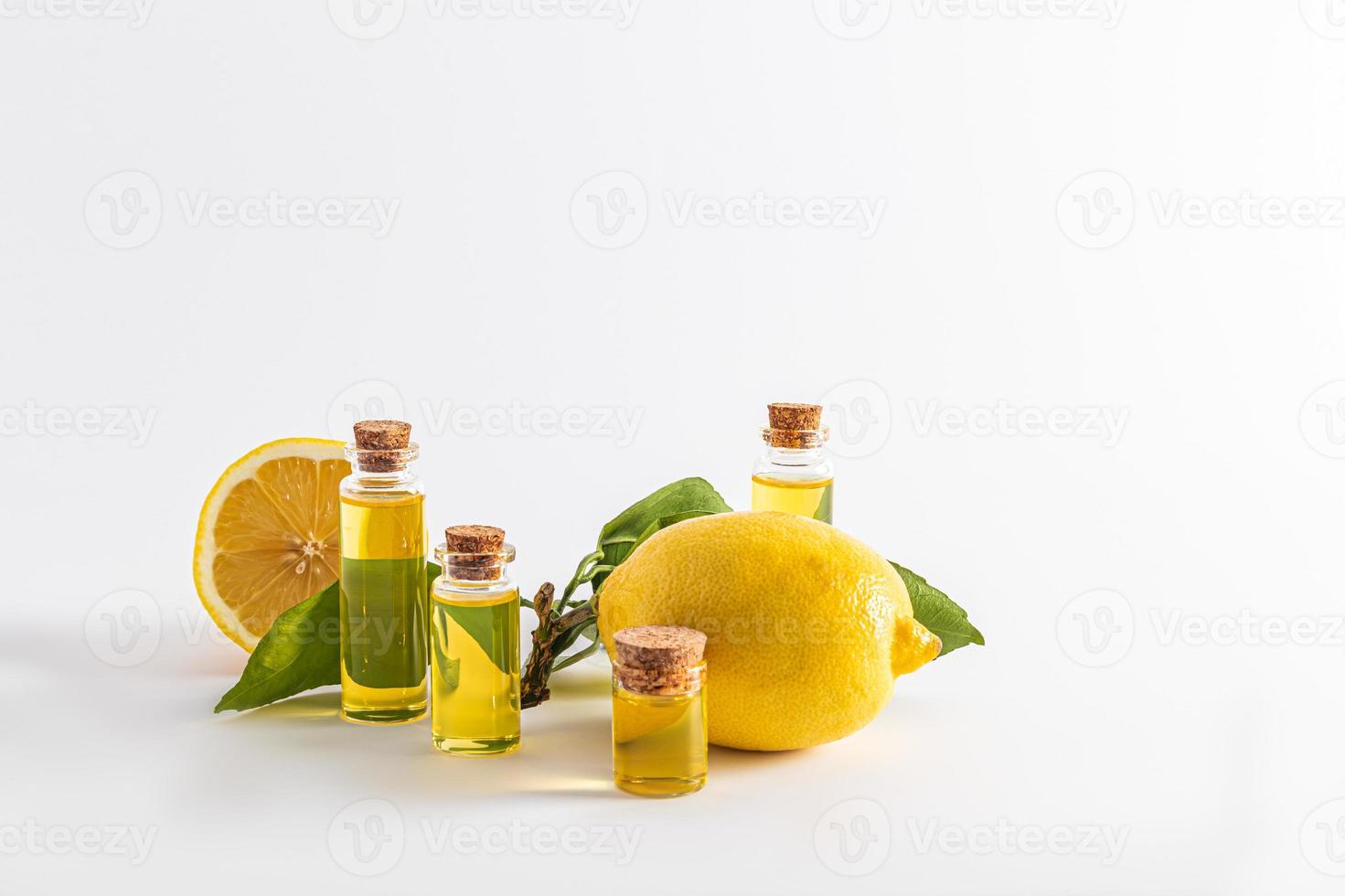 flera flaskor med en propp med en naturlig kosmetisk produkt tillverkad av citron- grundläggande olja på en vit bakgrund. främre se. produkt presentation. foto