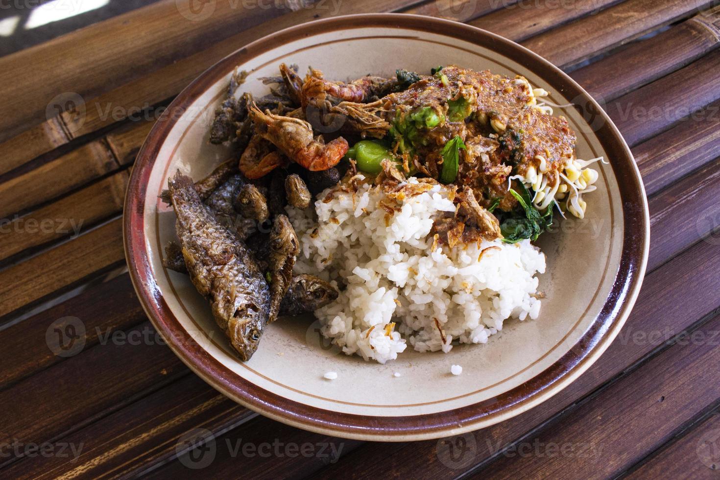 nasi pecel eller sego pecel är traditionell javanese ris maträtt av ångad ris med vegetabiliska sallad, jordnöt sås, tempeh, tofu böna groddar och crackers eller peyek kacang. på svart backgroud foto