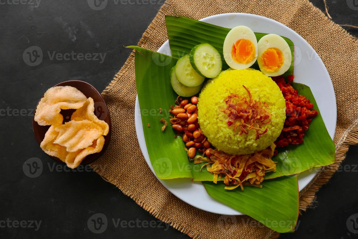 nasi kuning eller gul ris eller tumör ris är traditionell mat från Asien, tillverkad ris kokta med gurkmeja, kokos mjölk r foto