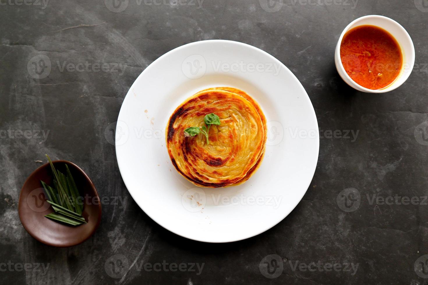 paratha bröd eller kanai bröd eller roti maryam, favorit frukost maträtt. eras på tallrik foto