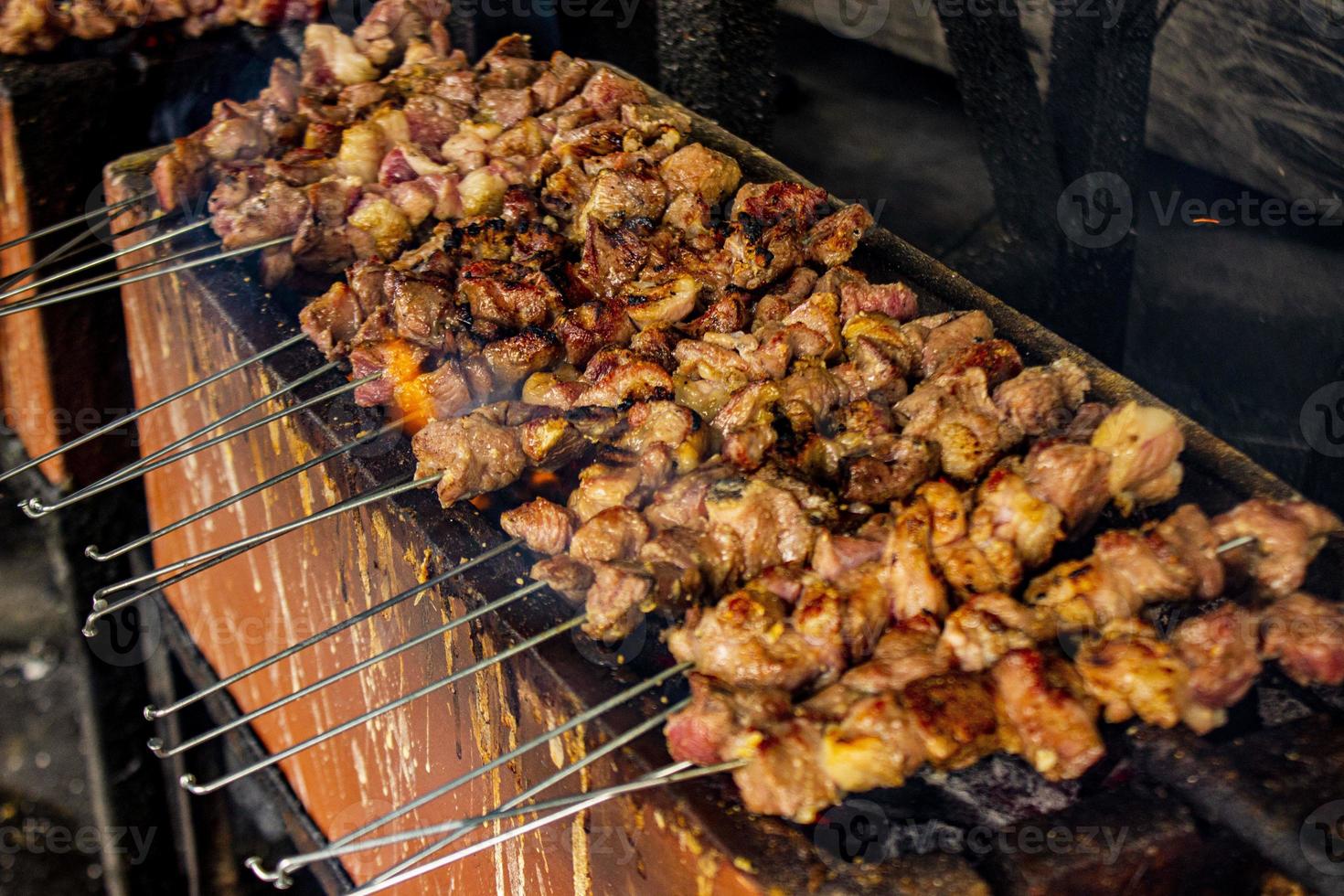 sate klatak eller sate kambing eller satay get, lamm, lamm eller kött get satay med träkol ingrediens på röd brand grillning förbi människor, indonesien matlagning satay. med selektiv fokus foto