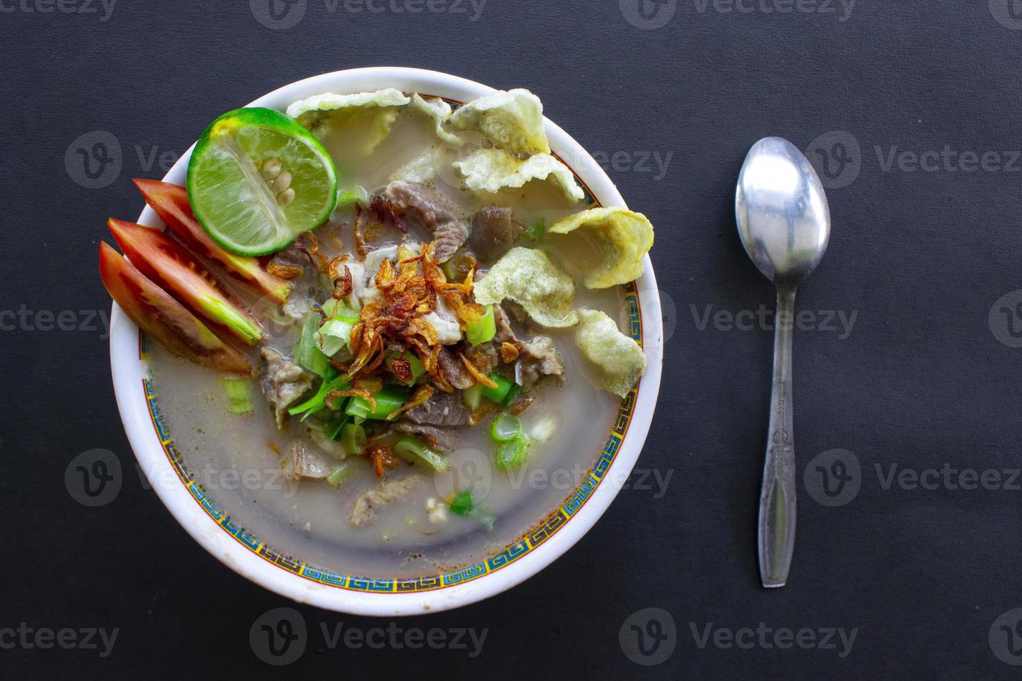 tröst kaki kambing en traditionell mat från betawi, jakarta Indonesien, tillverkad från fårkött eller lamm, inälvor, kryddor. isolerat på svart bakgrund.detta mat är tycka om lamm gryta på svart bakgrund foto