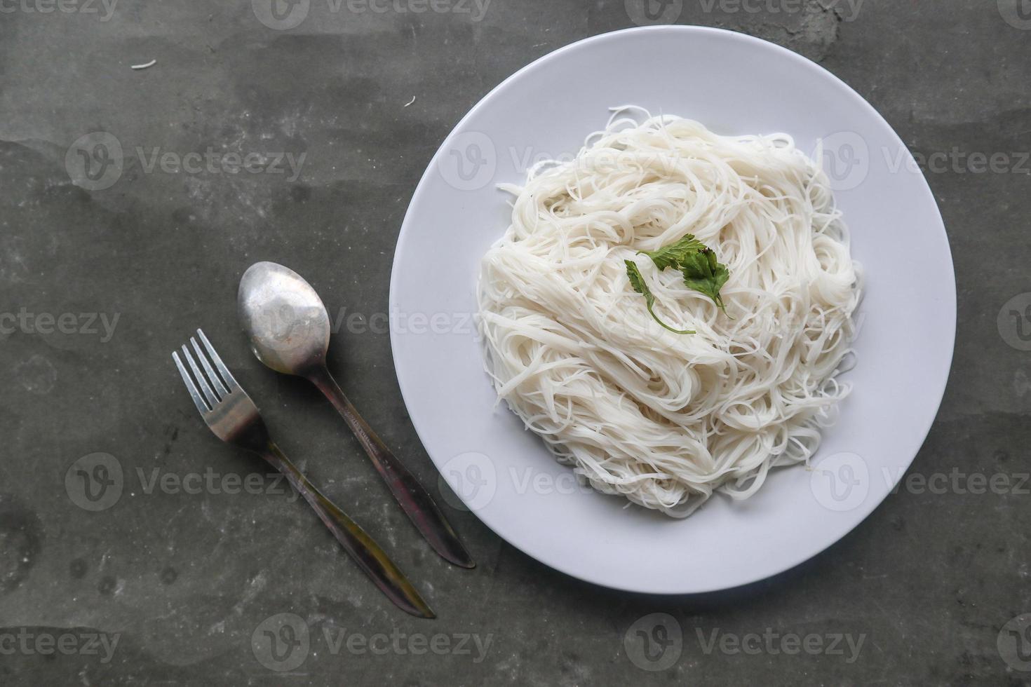 bihun eller vermiceller eller ris spaghetti eller ängel hår eras på tallrik isolerat på svart bakgrund foto