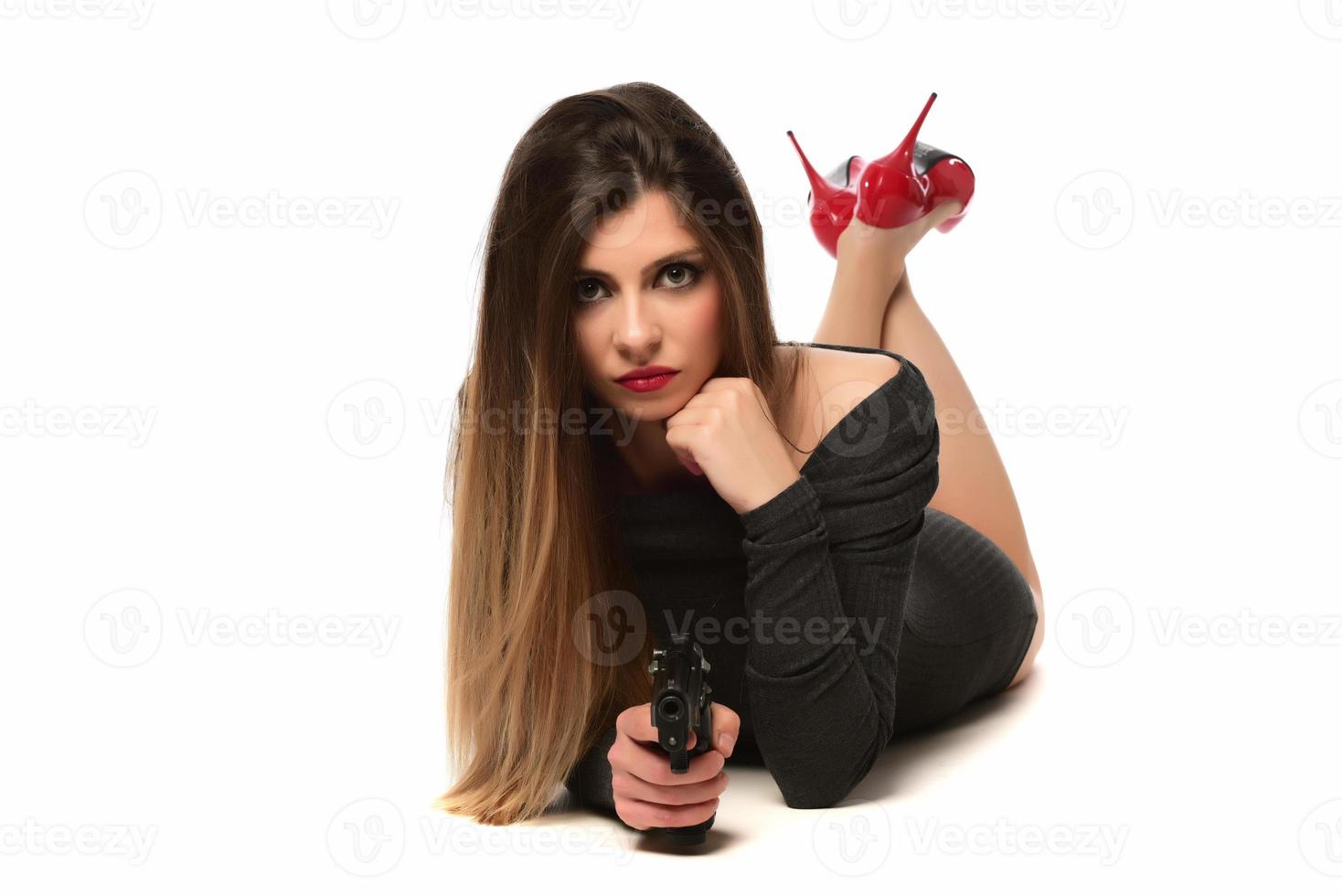 skön kvinna med röd hög kullar innehav en pistol. isolerat foto