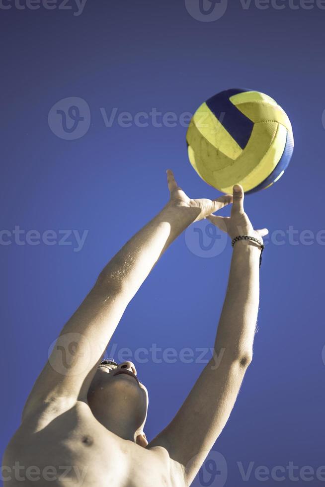 unge spelar volleyboll på skön sommar dag foto