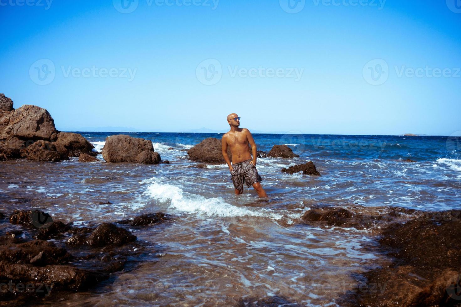 stilig man på de marin klippig Strand foto