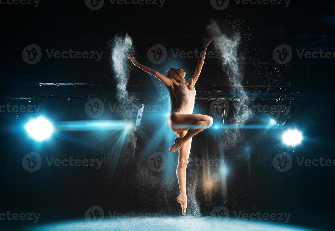 underbar vuxen ballerina Framställ på skede mot spotlights foto
