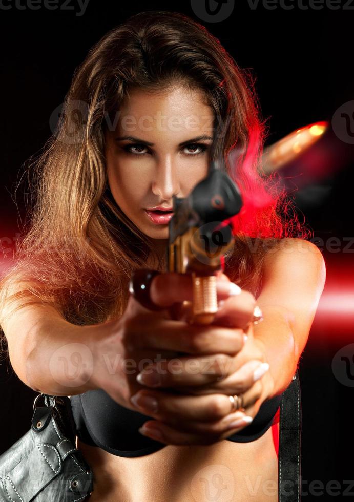 attraktiv kvinna skytte från gyllene pistol foto