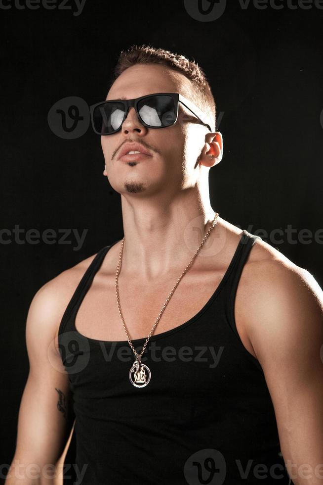 muskulös manlig i solglasögon och skjorta foto
