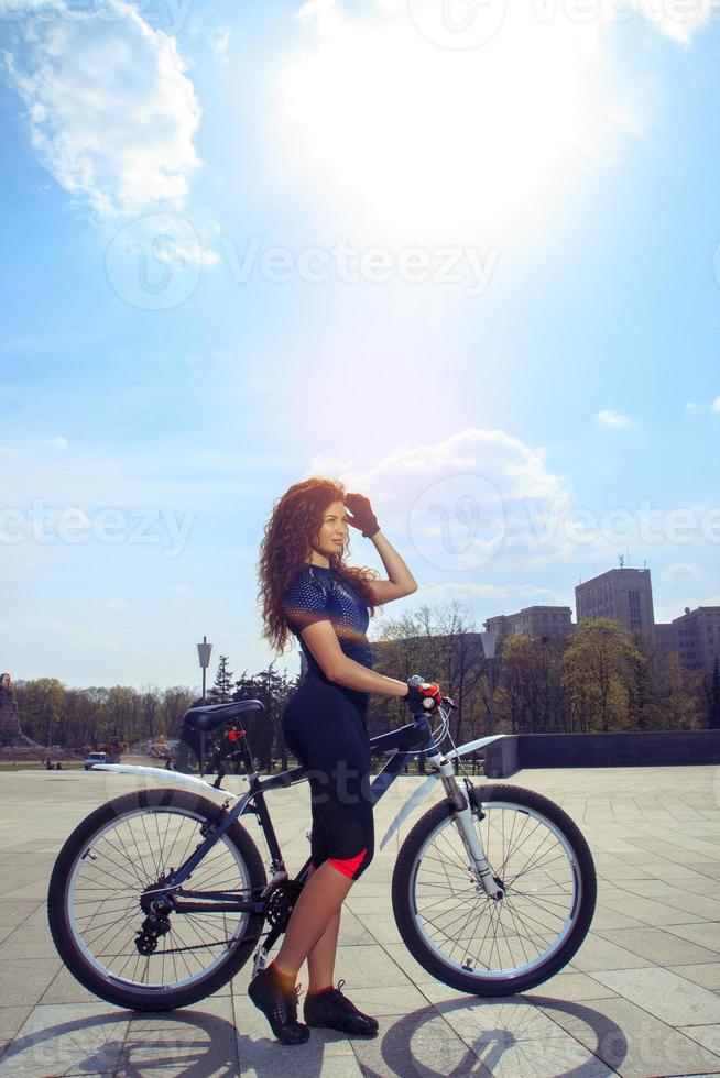 vertikal ung sexig flicka på cykel foto