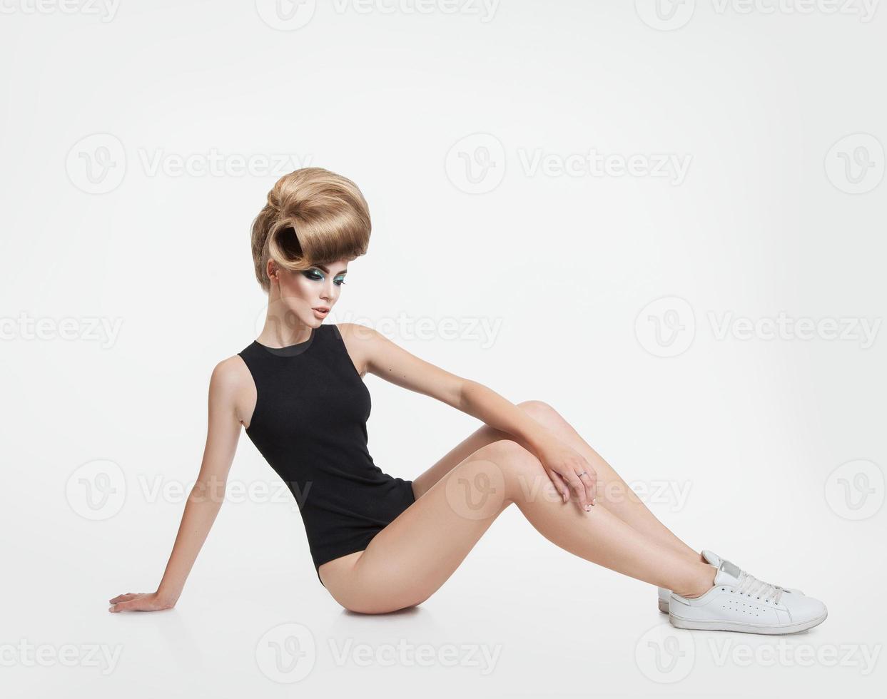 sötnos ung blond kvinna med kreativ frisyr i studio foto