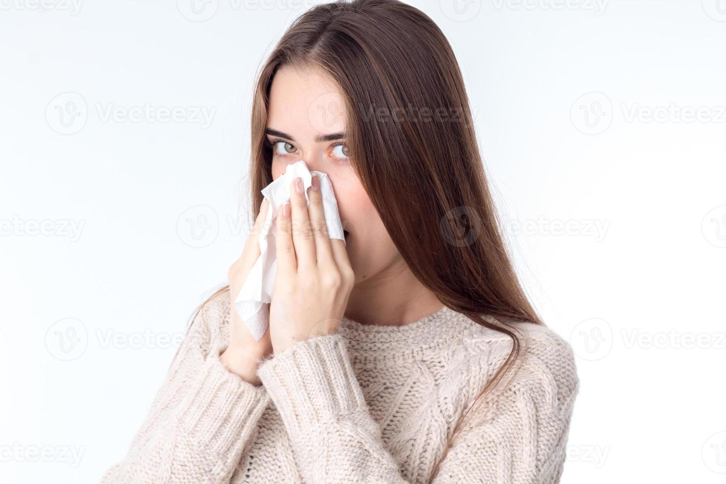 en ung flicka är sjuk och innehar näsduk nära de näsa foto