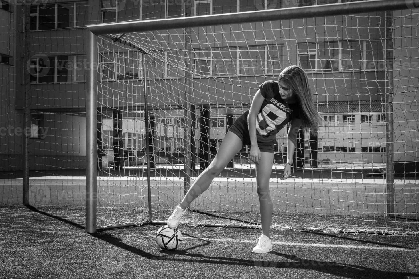 skön flicka med boll på de fotboll fält foto