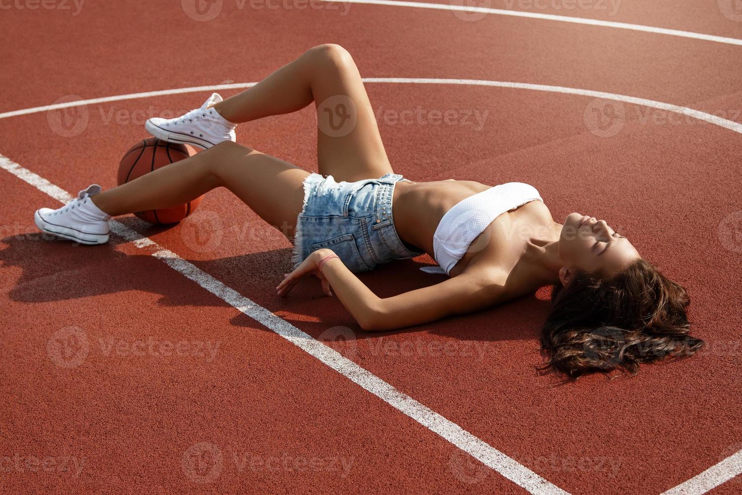 ung sexig kvinna med på en basketboll lekplats foto