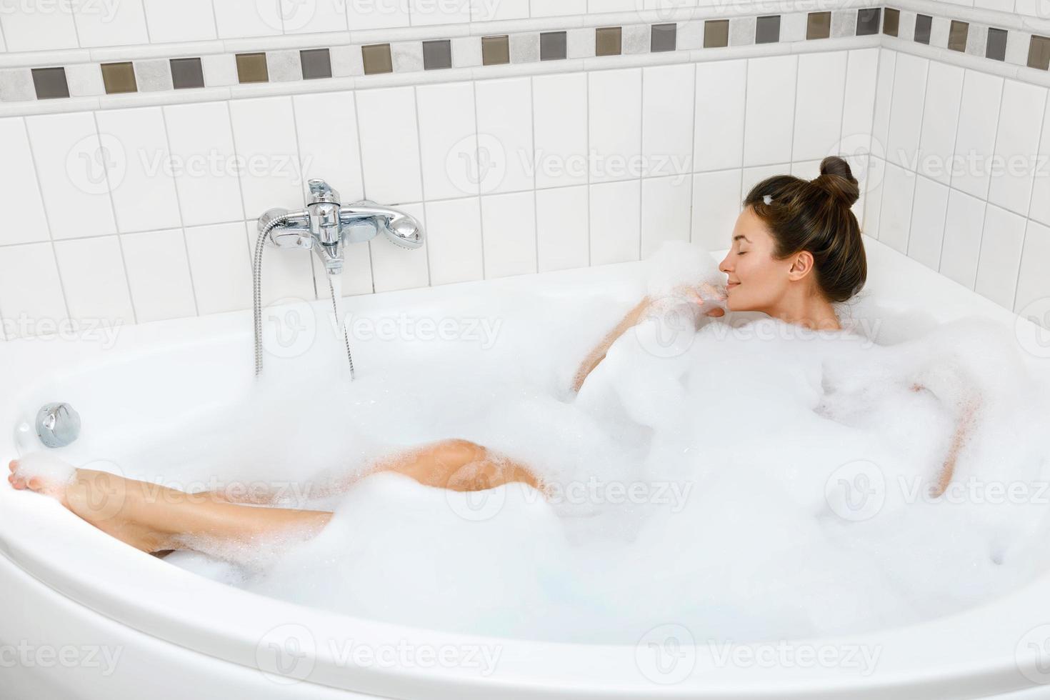 kvinna är tar bad med en skum foto