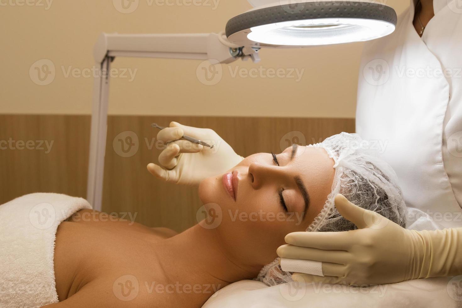 kvinna under en mekanisk ansikte rensning procedur foto