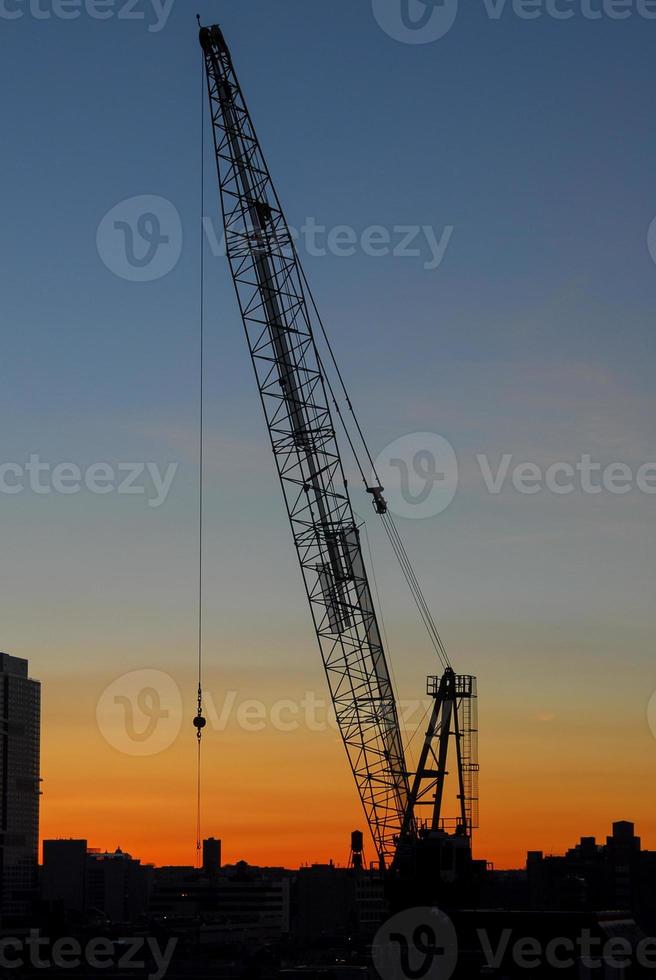 konstruktion mot en bakgrund av en silhuett av ny york stad på solnedgång. foto