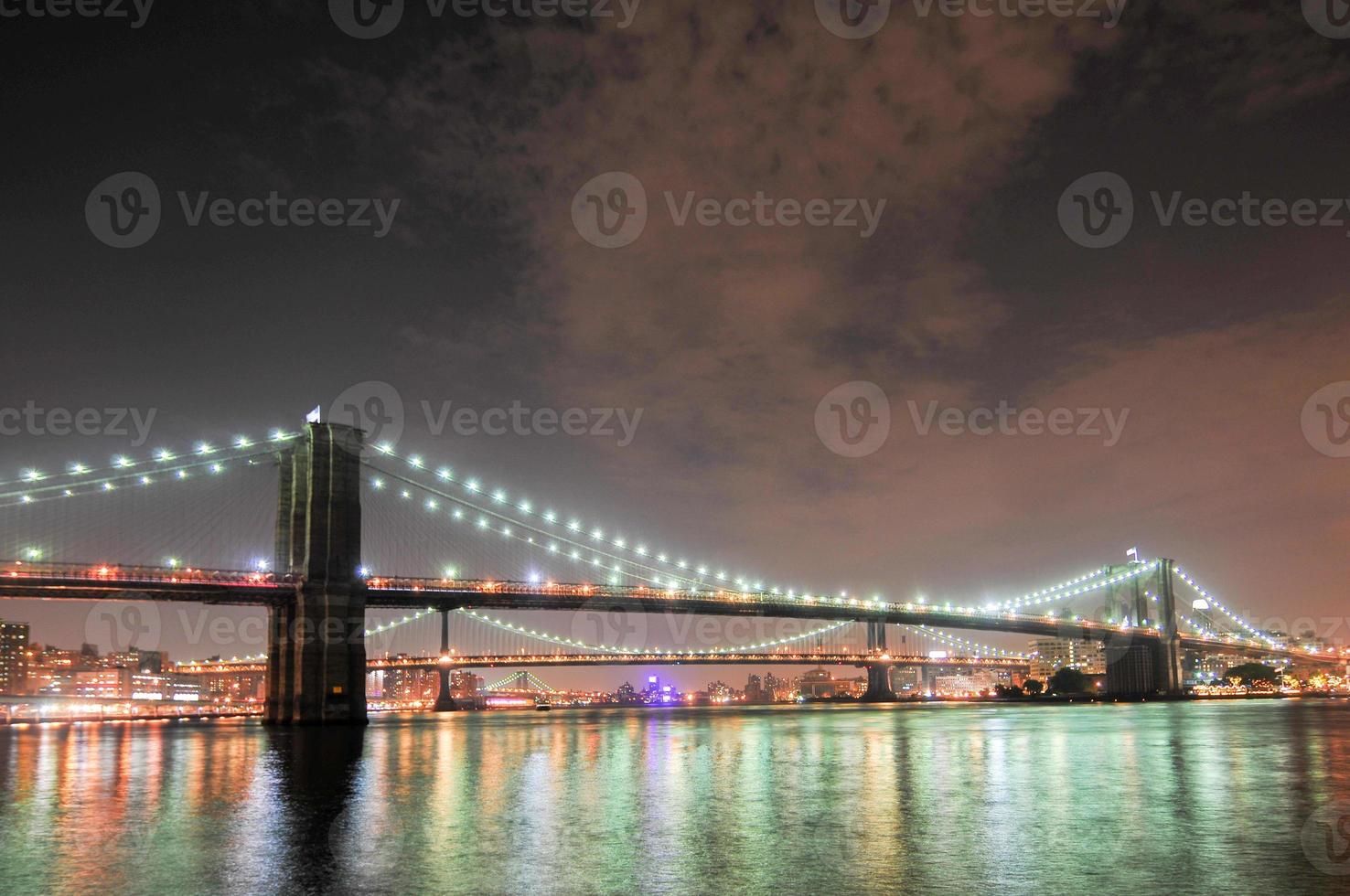 brooklyn bro närbild över östra floden på natten i New York City Manhattan med ljus och reflektioner. foto