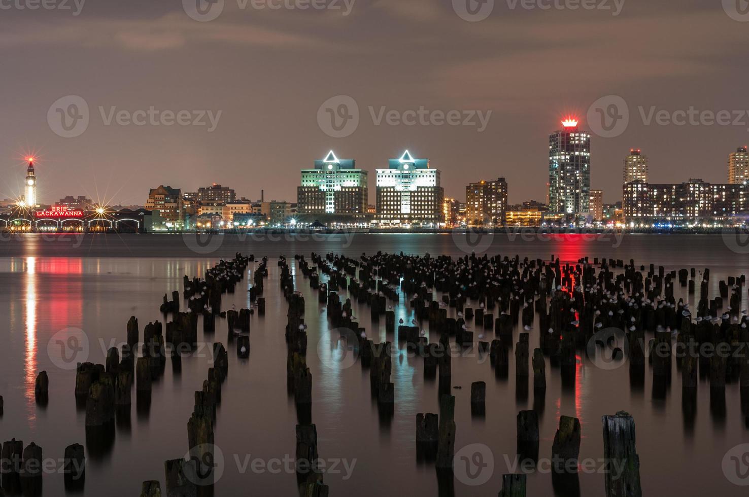 ny jersey horisont tvärs över gammal bryggor på natt från manhattan foto