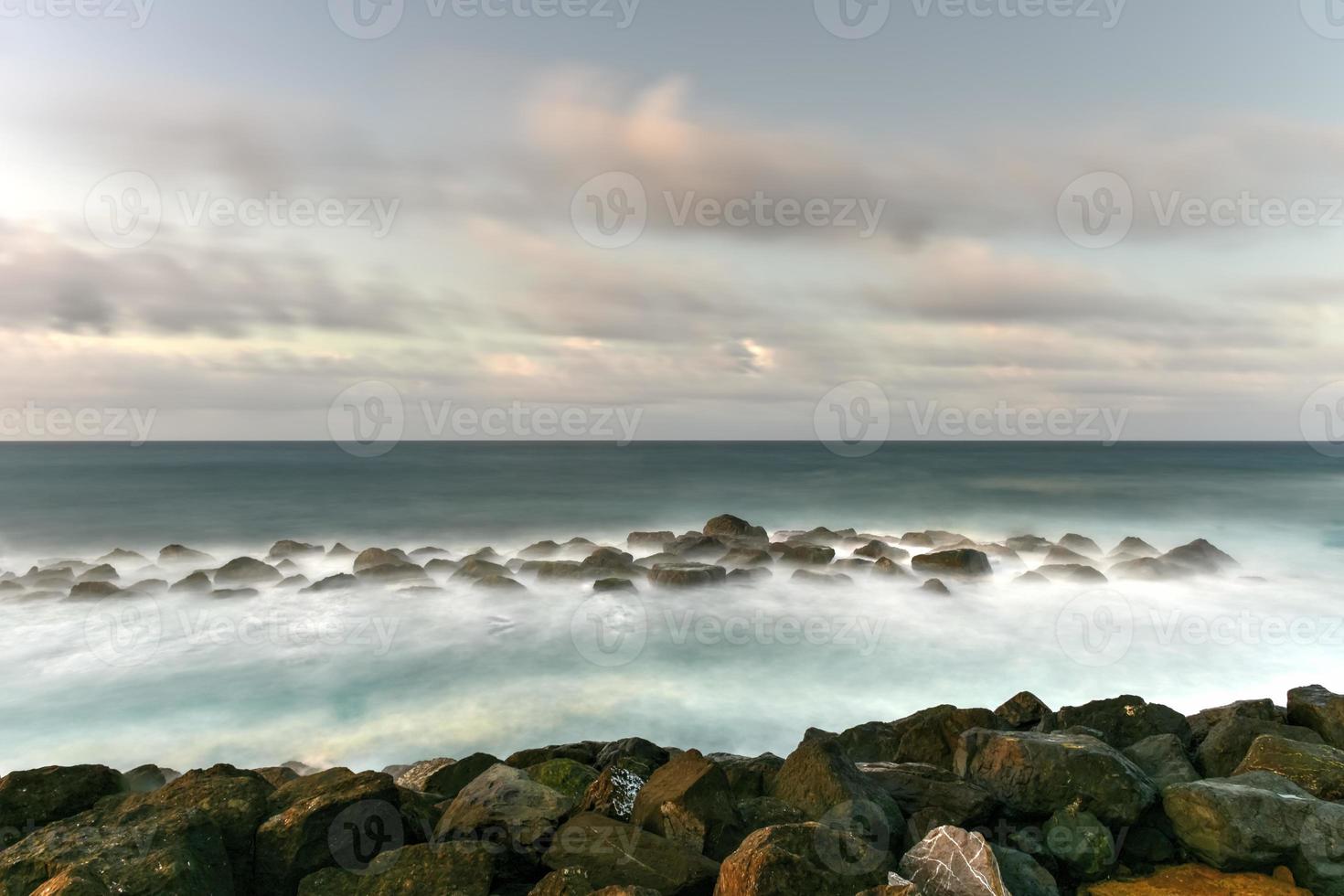 strand med vågor korsning mot de stenar av av san juan, puerto rico. foto