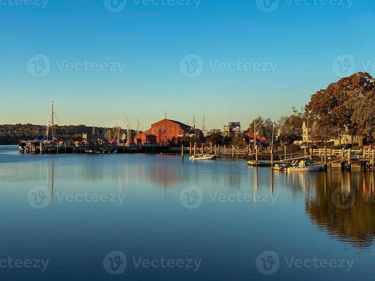 solnedgång längs de mystiker flod i mystiker, connecticut som reflektioner flyta ovan de fortfarande vatten. foto