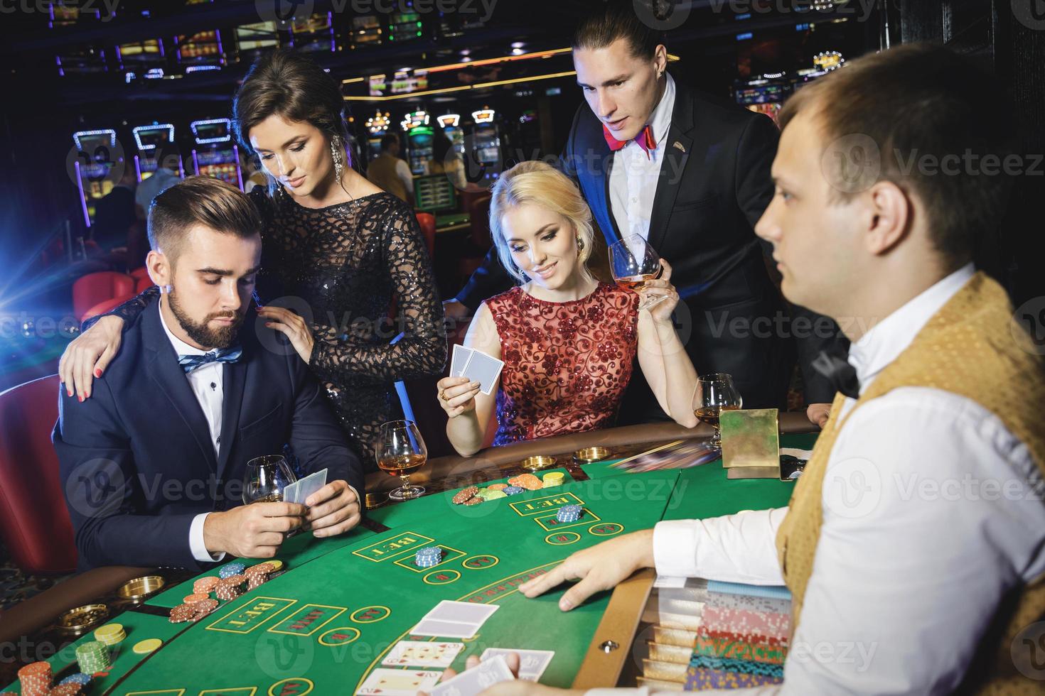 grupp av rik människor är spelar poker i de kasino foto