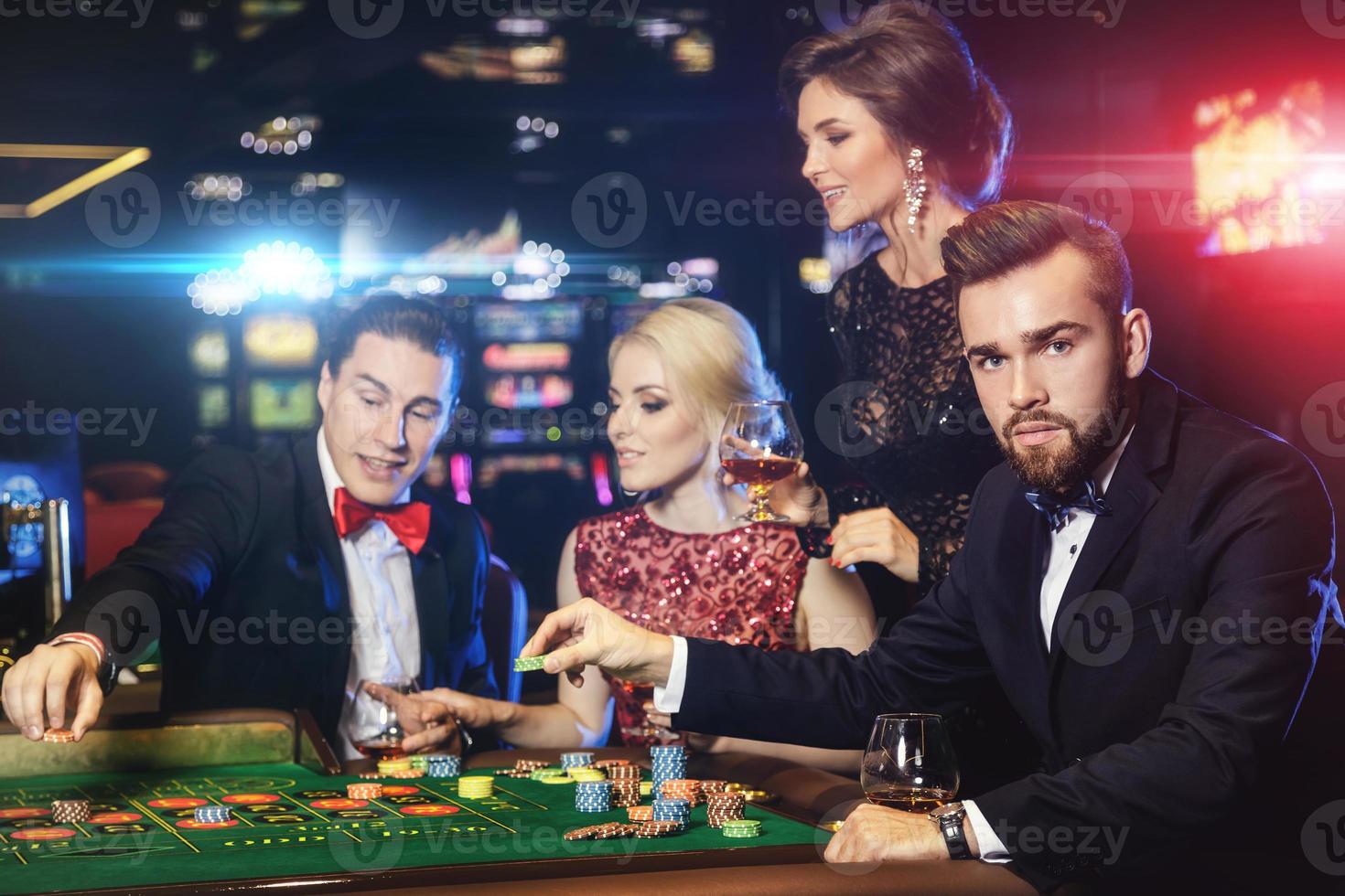 ung och rik människor spelar roulett i de kasino foto
