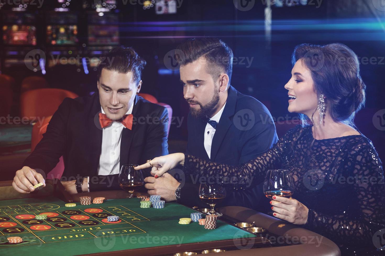 skön och rik människor spelar roulett i de kasino foto