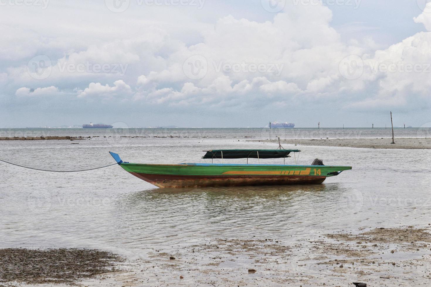 små grön flod trä- motor båt för fiske och transport bunden upp på de grund hav. foto
