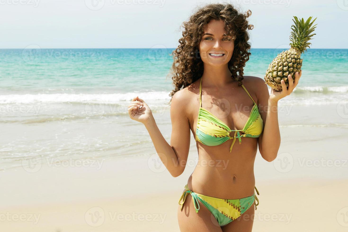 kvinna med en ananas frukt på de strand foto