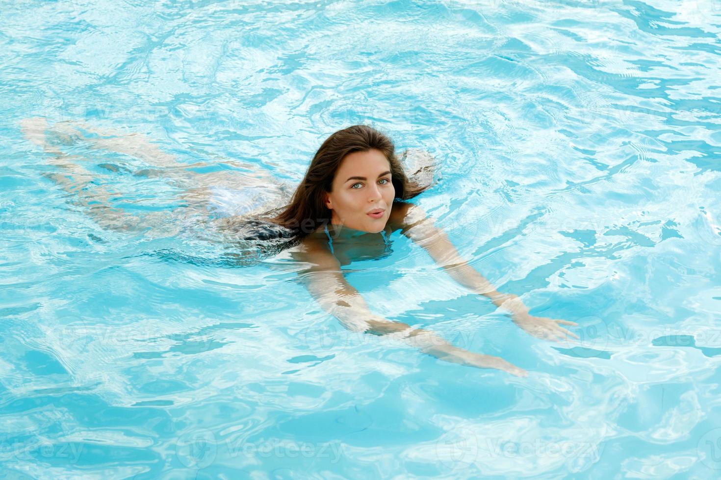 Lycklig kvinna simma i de simning slå samman foto