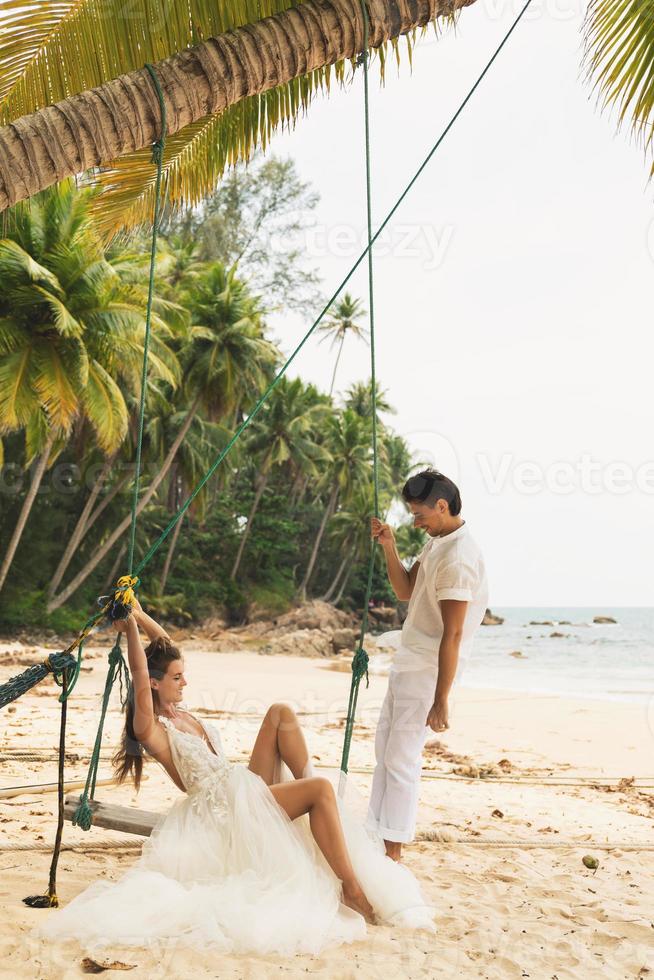 Lycklig ung gift par fira deras bröllop på de strand foto