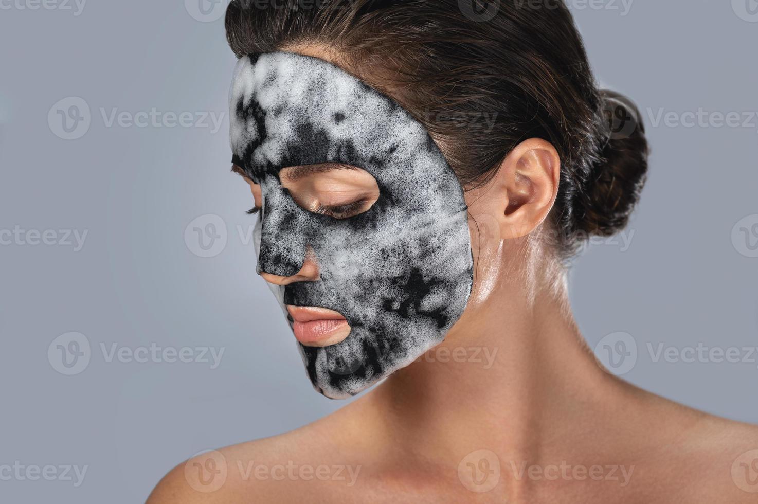 kvinna med bubbla ark mask på henne ansikte foto