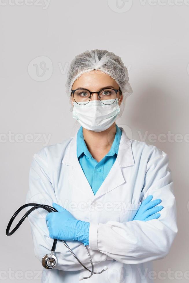 kvinna läkare med en stetoskop på grå bakgrund foto