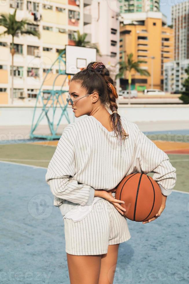 ung eleganta kvinna är Framställ på de choi hängd egendom basketboll domstol foto