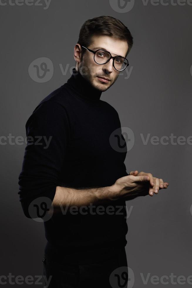 ung smart man bär glasögon och en vikta polo nacke foto