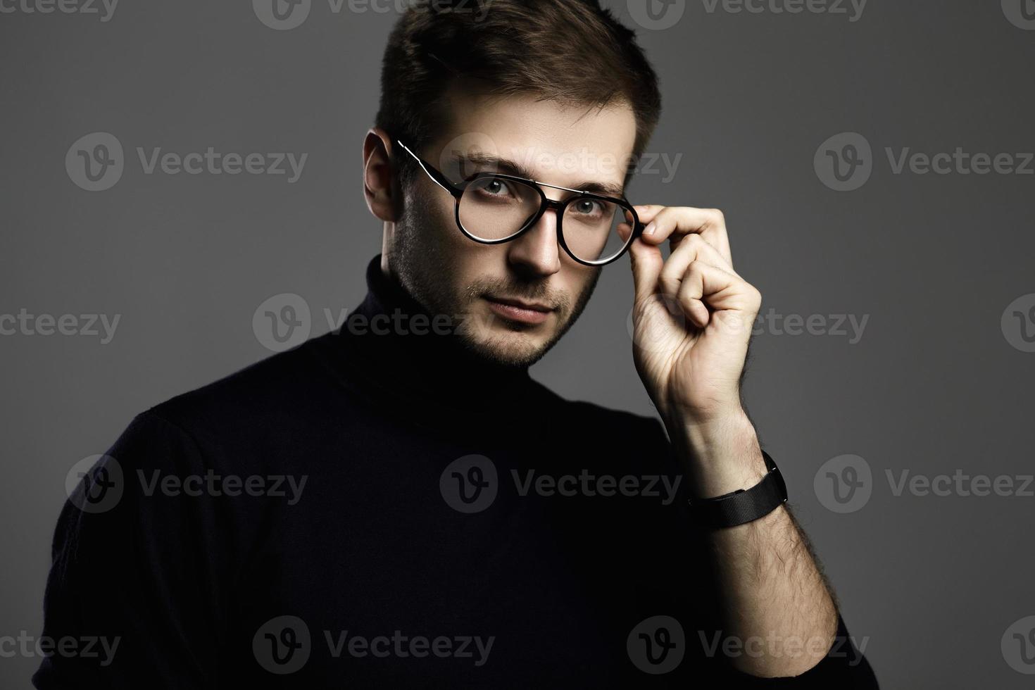 ung intelligent man bär turtleneck och glasögon foto