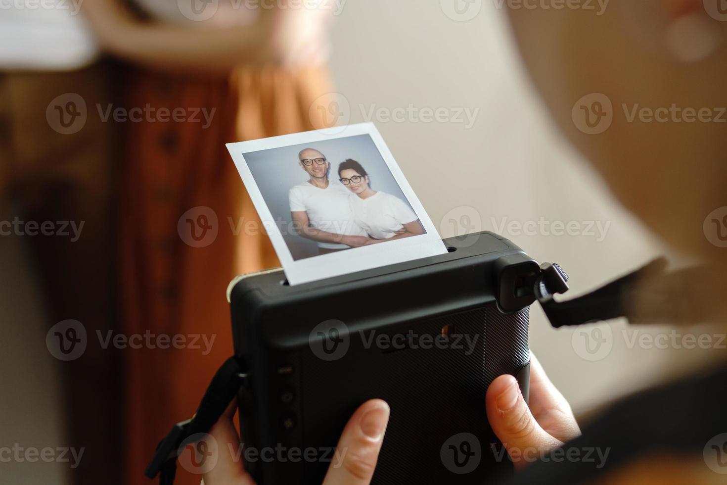 flicka tillverkad en Foto av henne föräldrar med en omedelbar kamera