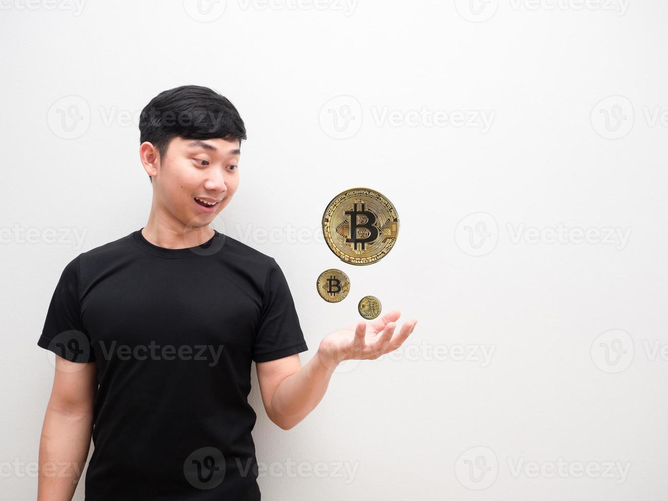 asiatisk man ser på bitcoin på hand Lycklig ansikte och leende de digital pengar begrepp på vit isolerat bakgrund foto