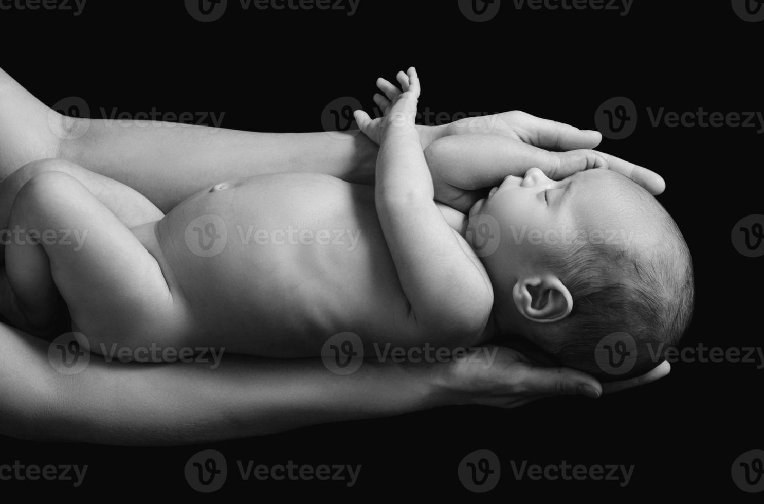 söt nyfödd bebis i de mors händer foto
