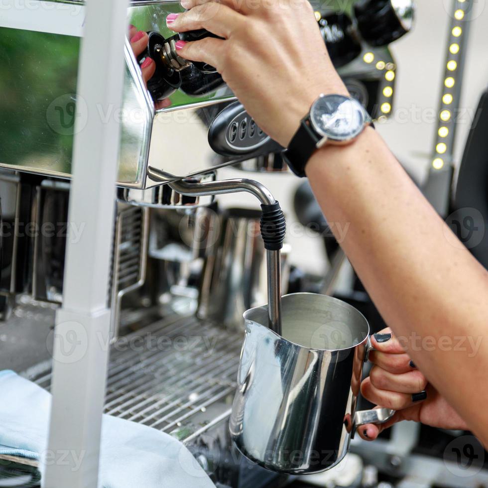 Barista är framställning kaffe med en mjölk foto