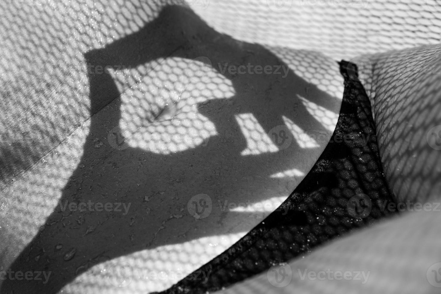 kvinna mage täckt med retikulerade skugga från hängmatta foto