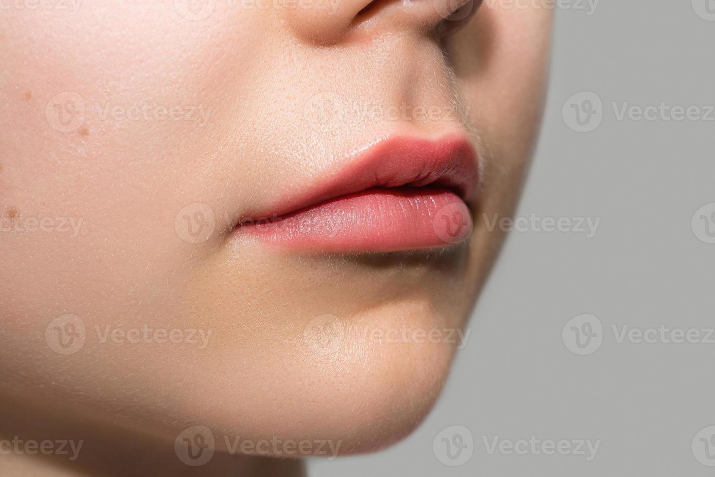 kvinna mun efter permanent smink läpp rodnande procedur foto
