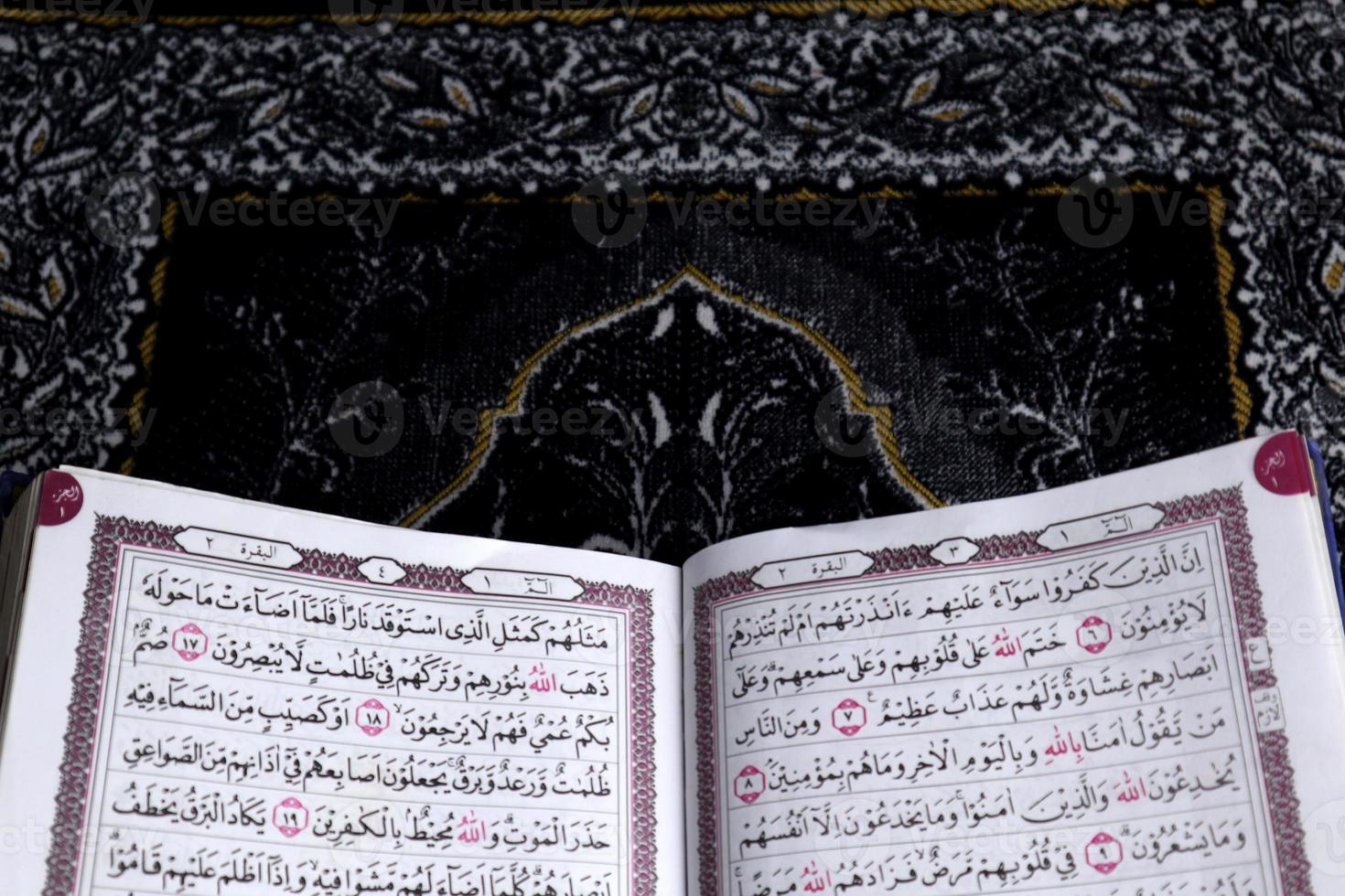 al-koranen som är ovan de bön matta med en svart bakgrund foto