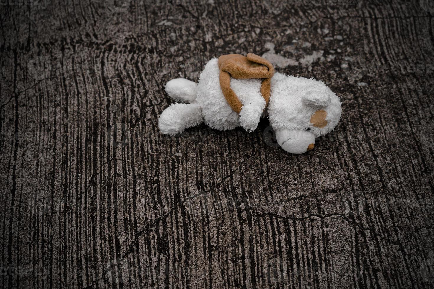ensam teddy Björn sömn på cement golv för skapas vykort av internationell saknas barn, bruten hjärta, ensam, ledsen, ensam oönskade söt docka förlorat. foto