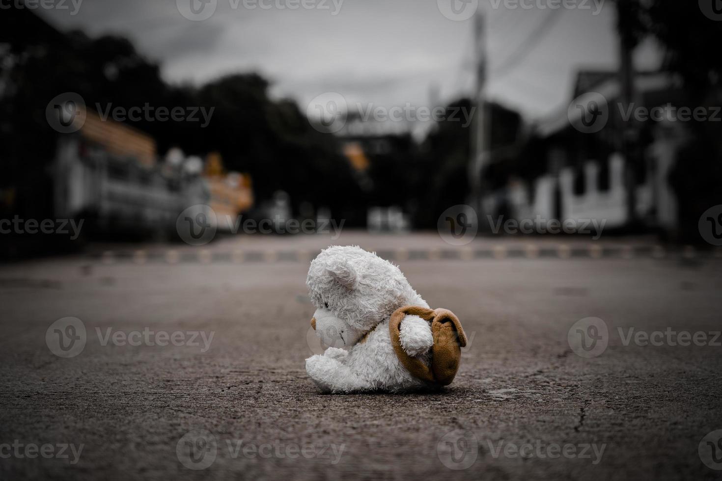 ensam teddy Björn sömn på cement golv för skapas vykort av internationell saknas barn, bruten hjärta, ensam, ledsen, ensam oönskade söt docka förlorat. foto