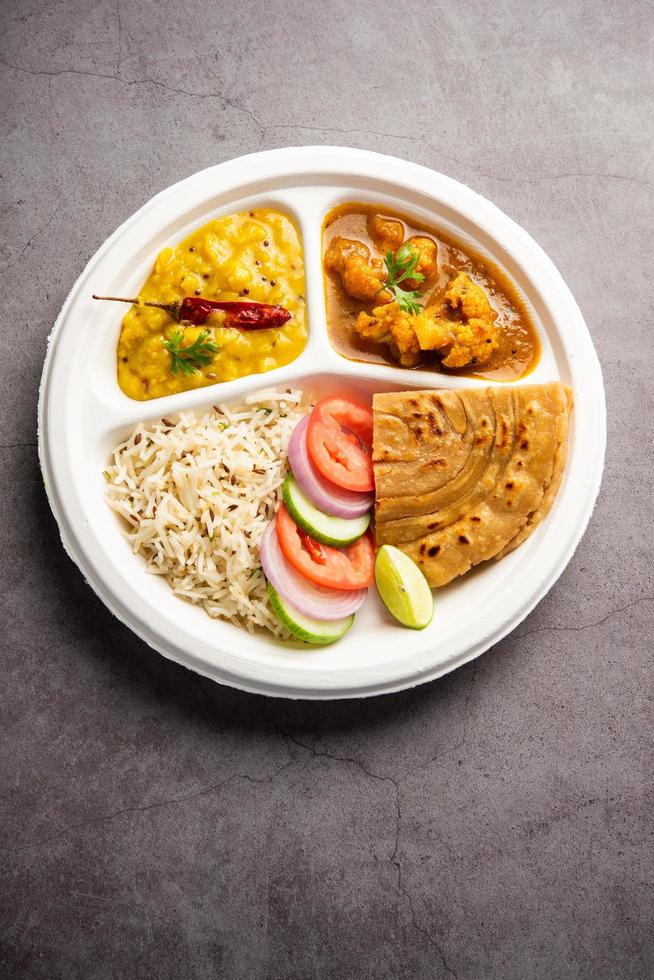 indisk mini måltid paket tallrik eller combo thali med gobi masala, roti, dal tarka, jeera ris, sallad foto