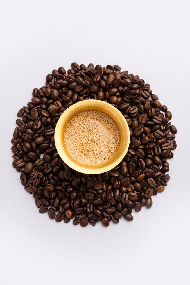 söder indisk filtrera kaffe eras i en traditionell tumlare eller kopp över rostad rå bönor foto